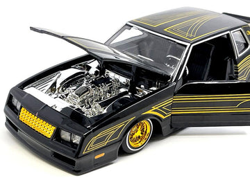 1986 Chevy Monte Carlo Ss Lowrider Black Metallic With Gold Graphics And Wheels Lowriders Series 1/24 Diecast Model Car By Maist