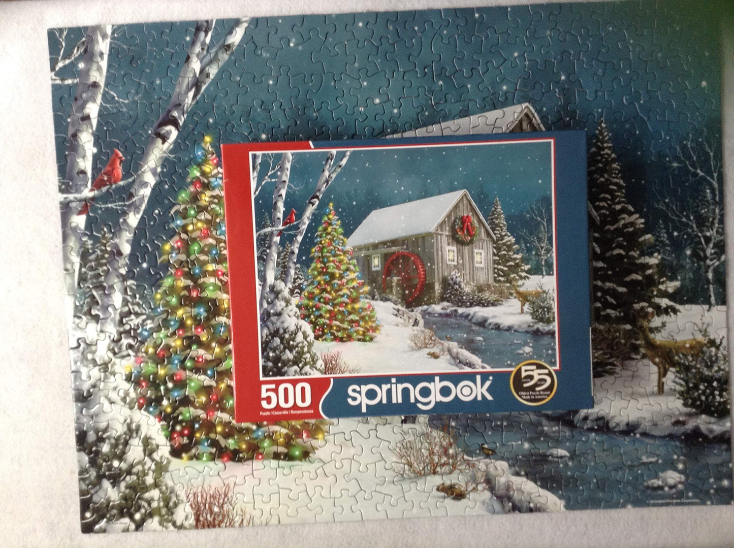 Springbok The Falling Snow 500 Piece Jigsaw Puzzle For Adults Features A Holiday Cabin Glowing In The Snow With A Decorated Christmas Tree Beside It